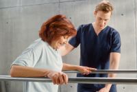 portrait-of-strong-senior-middle-aged-with-leg-injury-successfully-walks-holding-parallel.jpg